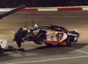 Kaleb Allison's destroyed race car is towed back to the pits after a crash.  Photo by Steve Brown