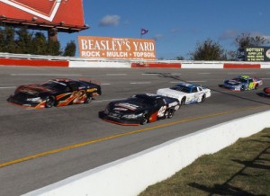 Dennis Reno (2x) and Chad Finley (42) lead a pack of cars through turn three during Saturday's running of the All American 400 at Fairgrounds Speedway Nashville.  Photo by Steve Brown