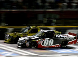 Kasey Kahne (00) takes the checkered flag ahead of Erik Jones (4) to win Friday night's NASCAR Camping World Truck Series race at Charlotte Motor Speedway.  Photo by Brian Lawdermilk/Getty Images