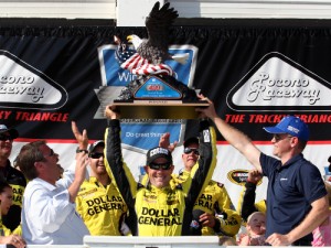 Matt Kenseth celebrates with the trophy in victory lane after winning Sunday's NASCAR Sprint Cup Series race at Pocono Raceway.  Photo by Tim Bradbury/Getty Images