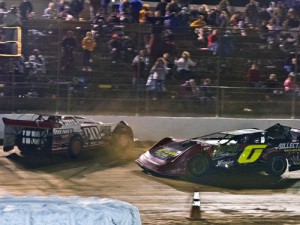 Josh Henry (00) spins backwards over the finish line to win the Late Model feature after contact with Ross White (0) Saturday night at 411 Motor Speedway.  Photo: Nv-UsPhoto.com