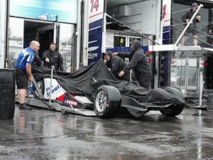 The Dale Coyne Racing team covers up the car of Pippa Mann as the rain falls at Pocono Raceway. Sunday's Verizon IndyCar Series race at Pocono has been postponed by rain to Monday afternoon. Photo by Chris Owens