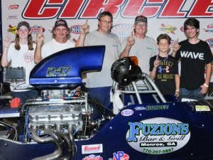 Mike Brown and his family celebrates in Atlanta Dragway's victory lane. Brown edged out Travis Bryant to take the win in the second Super Pro Summit ET final Saturday. Photo by Jerry Towns