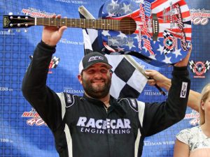 Bubba Pollard celebrates with the All American 400 guitar trophy after scoring the victory in Sunday's Super Late Model race at Fairgrounds Speedway Nashville.  Photo by Rich Corbett