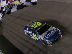 Jimmie Johnson takes the checkered flag to win Sunday night's NASCAR Sprint Cup Series race and the 2016 NASCAR series championship at Homestead-Miami Speedway.  Photo by Sean Gardner/NASCAR via Getty Images